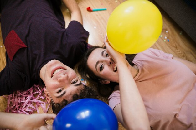 High angle happy teenagers laying on the floor