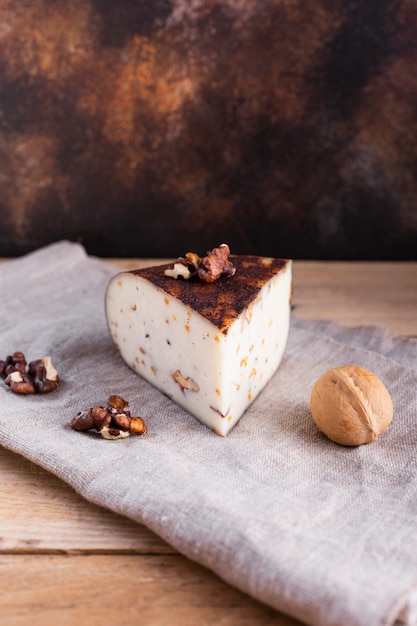 Formaggio a pasta dura dell'angolo alto con le noci sulla tabella