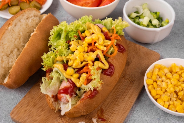 High angle of hot dog with salad and corn