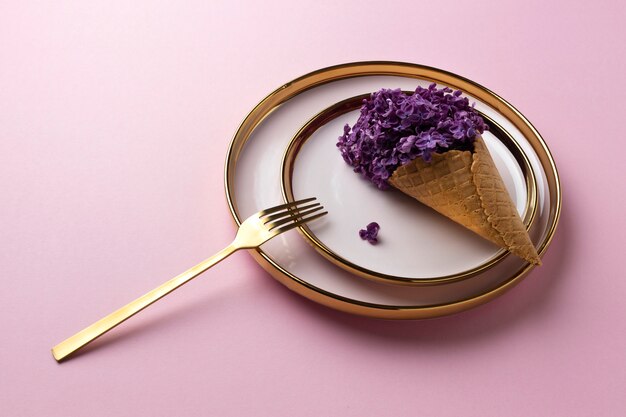 High angle ice cream cone with flowers on plate