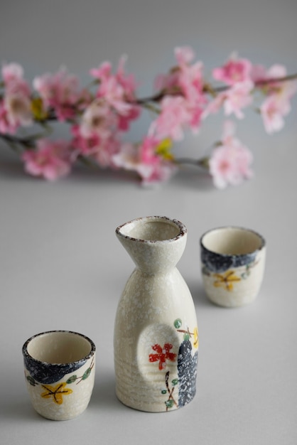 Free photo high angle japanese cups and flowers