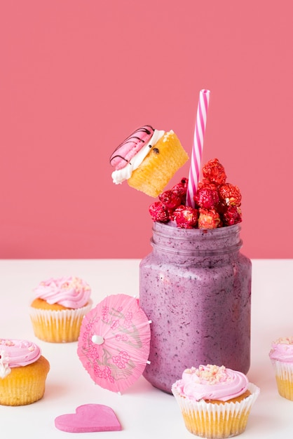 Free photo high angle of jar of dessert with fruit and muffins