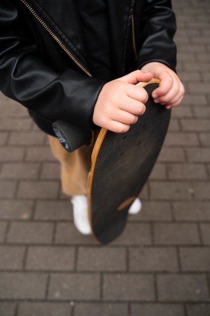 High angle kid holding skateboard