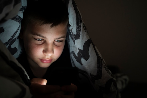 High angle kid holding smartphone