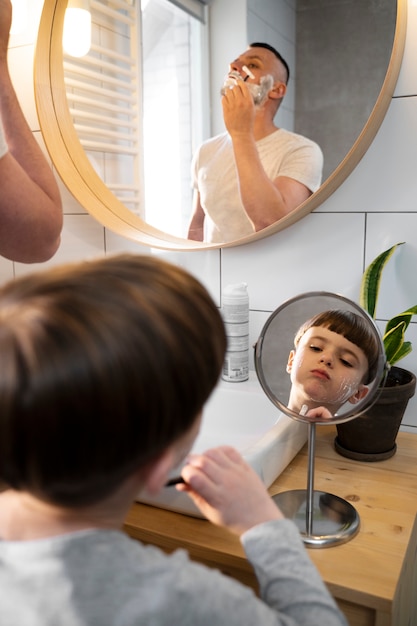 거울로 면도하는 법을 배우는 하이앵글 아이