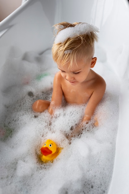 Free photo high angle kid playing in bathtub