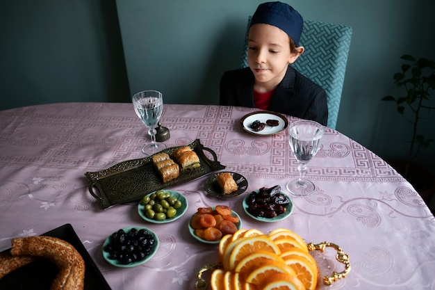 Foto gratuita bambino dell'angolo alto che si siede alla tavola