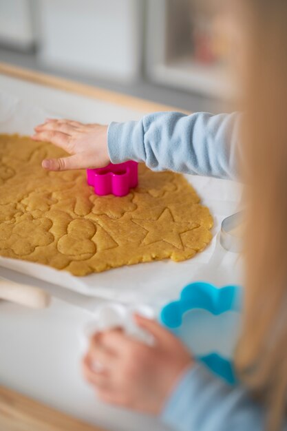 ベーキングのための形を使用している高角度の子供