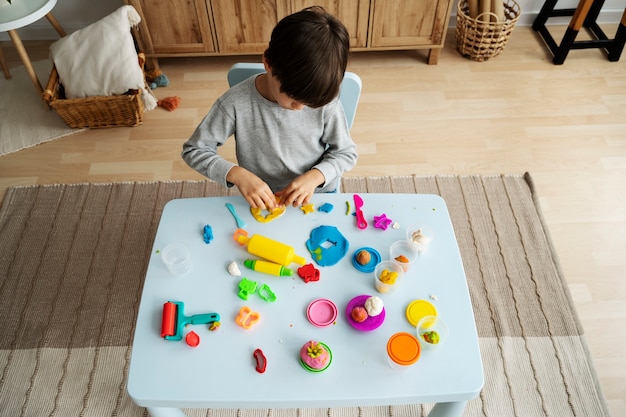 High angle kid with playdough indoors