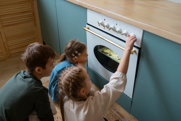 Foto gratuita bambini ad alto angolo che cuociono i biscotti