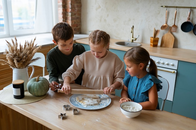 Free photo high angle kids cooking together  in kitchen