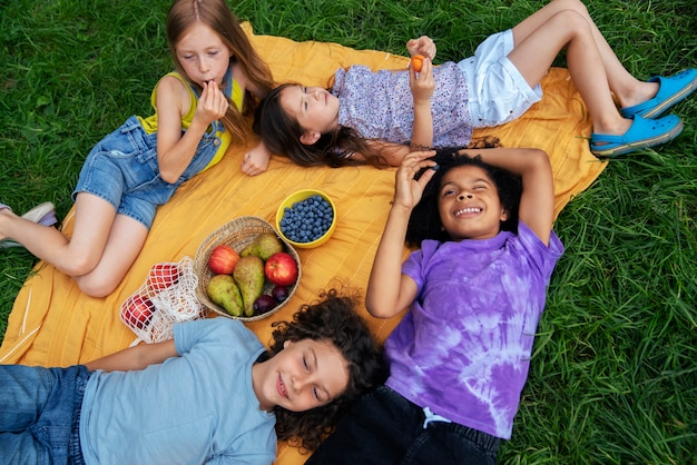 Free photo high angle kids laying on cloth