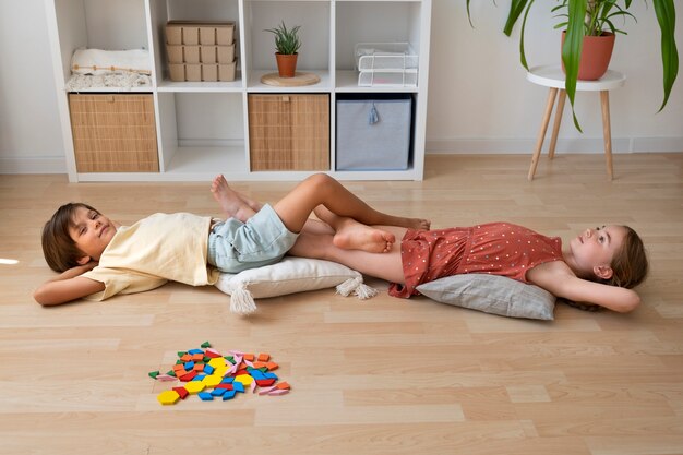 Дети под большим углом лежат на полу