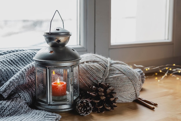 Free photo high angle lamp and candle with pine cones and yarn