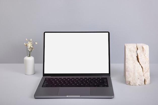 high angle laptop and flowers vase