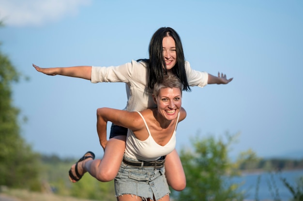 High angle lesbian couple piggy back ride