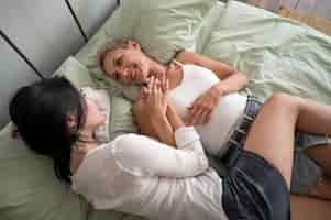 Free photo high angle lesbian couple sitting in bed