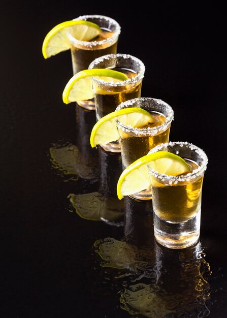 High angle line of gold tequila shots