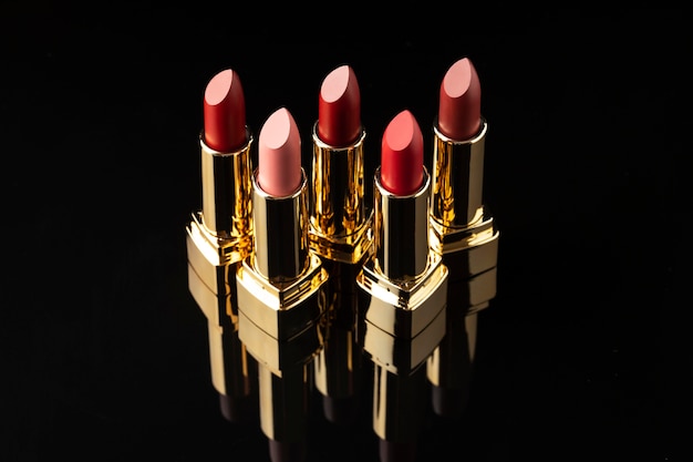 Free photo high angle lipsticks arrangement with dark background