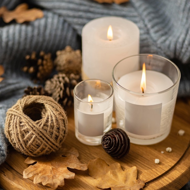 High angle of lit candles with string and pine cones