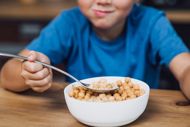 High angle little boy eating cereals