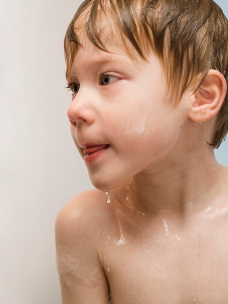 Free photo high angle little boy having bath