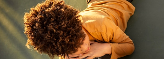 High angle little boy lying on a basketball field