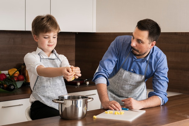 High angle little boy with father cooking