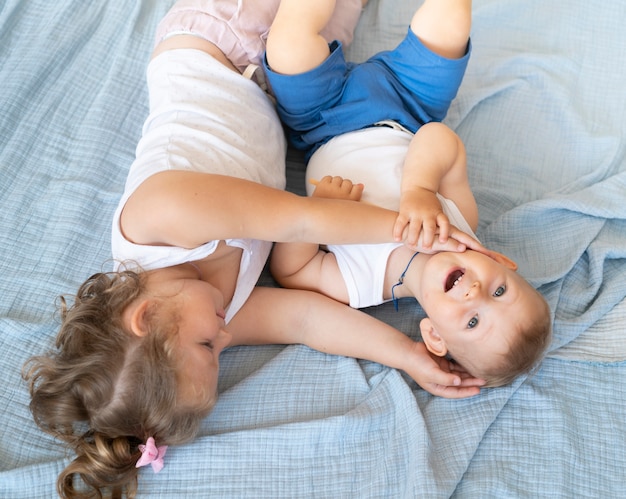 ハイアングル小さな子供たちがベッドに座って