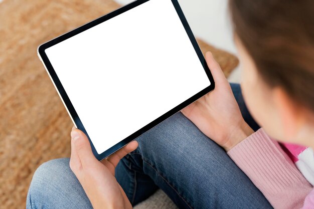 High angle of little girl at home using tablet