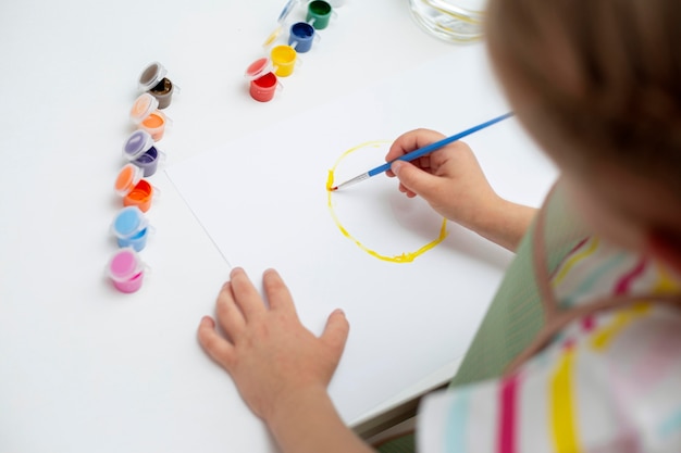 High angle little girl painting