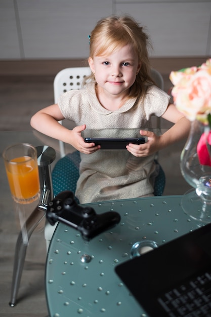 High angle little girl playing games with joystick