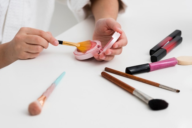 High angle little girl playing with her mothers cosmetics