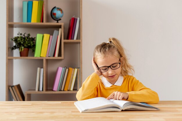 High angle little girl with glasses reading