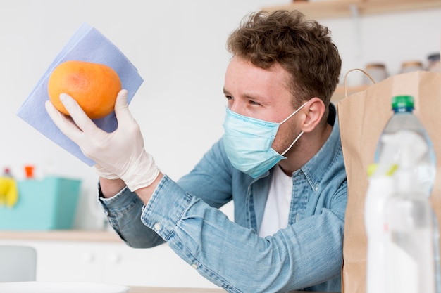 Free photo high angle male cleaning fruit