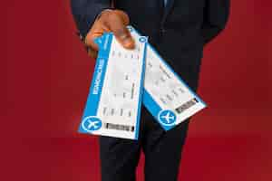 Free photo high angle male flight attendant holding tickets