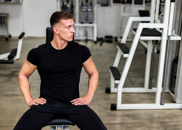 Foto gratuita maschio dell'angolo alto alla palestra sulla pausa