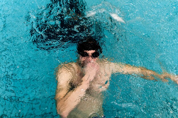 High angle male holding breath underwater