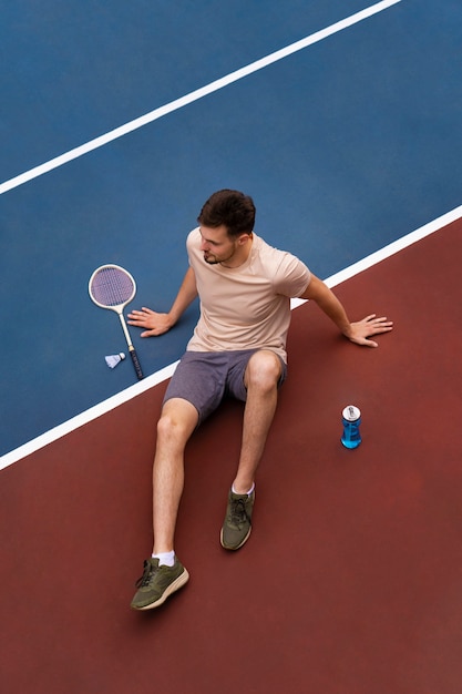 Foto gratuita uomo dell'angolo alto sul campo di badminton