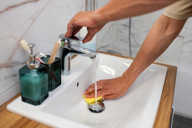 High angle man cleaning the sink