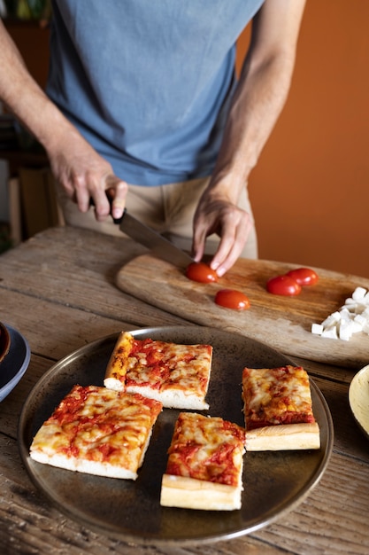 Free photo high angle man cutting tomatoes