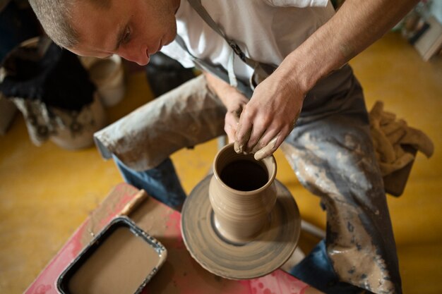 High angle man doing pottery