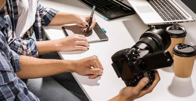 Uomo dell'angolo alto che tiene una macchina fotografica