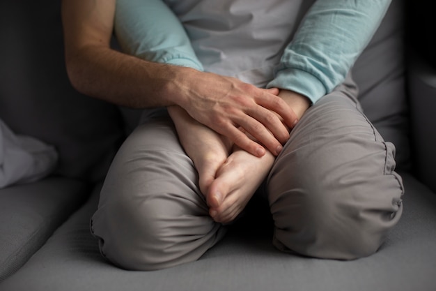 Free photo high angle of man holding girlfriend's feet