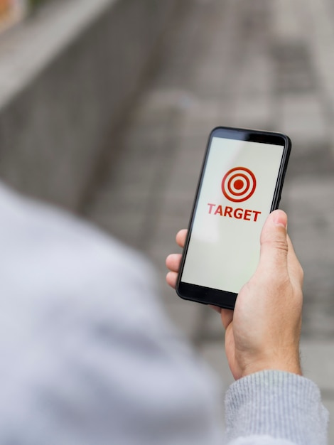 High angle of man holding smartphone with target on it