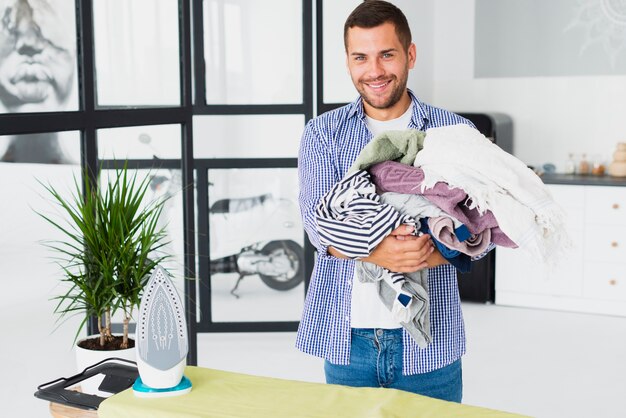 High angle man holding stack of clothes