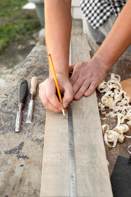 High angle man marking a wood with a pencil