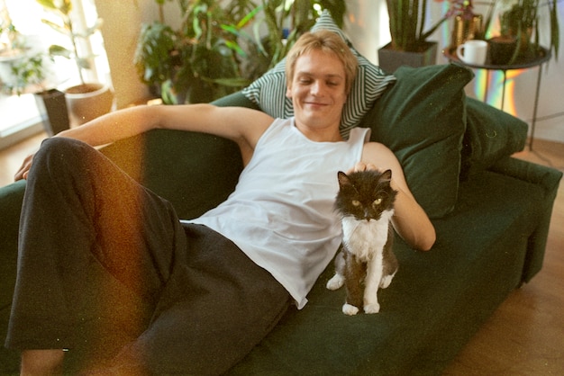 Бесплатное фото Мужчина под высоким углом на диване с кошкой