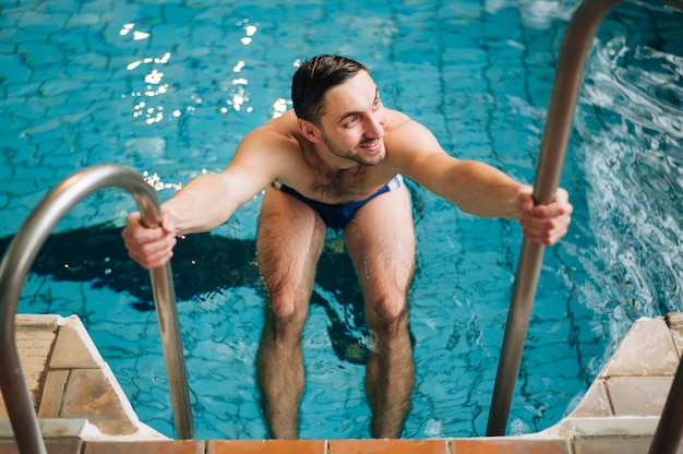 High angle man os swimming pool stairs