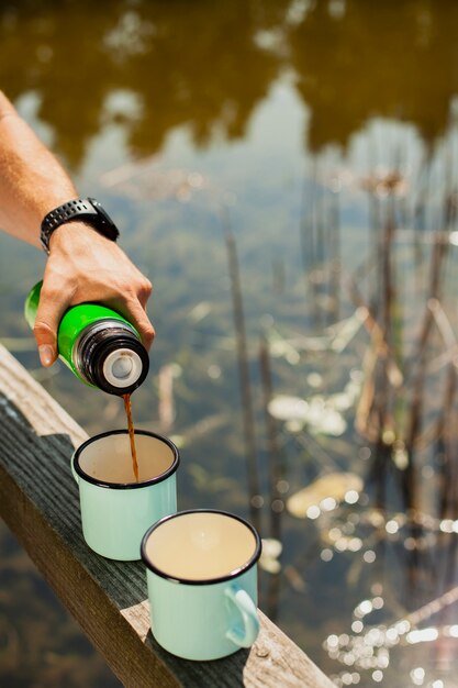 カップに飲み物を注ぐ高角度の男